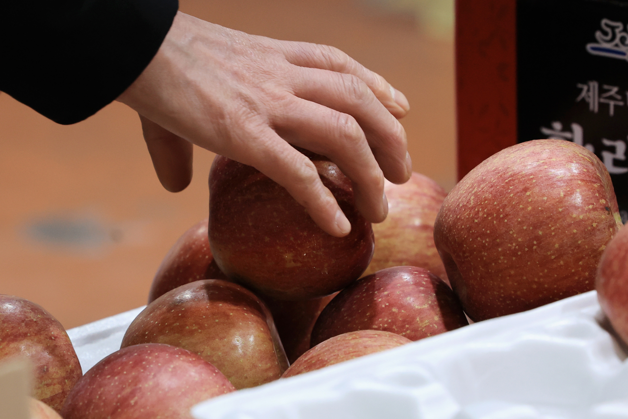 A person picks up an apple being sold at Garak Market in Songpa-gu, southern Seoul, Tuesday. (Yonhap)