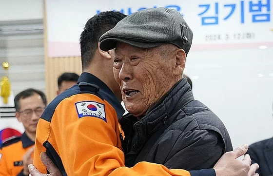 Kim Gyeong-su (right) embraces a member of the National Fire Agency at Gangbuk Fire Station in Daegu on Tuesday. (Courtesy of National Fire Agency)