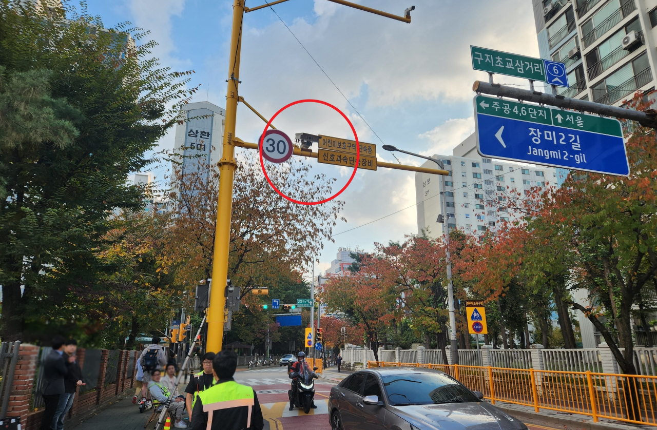 A bi-directional traffic enforcement camera, circled in red, is installed in a school zone. (Korean National Police Agency)