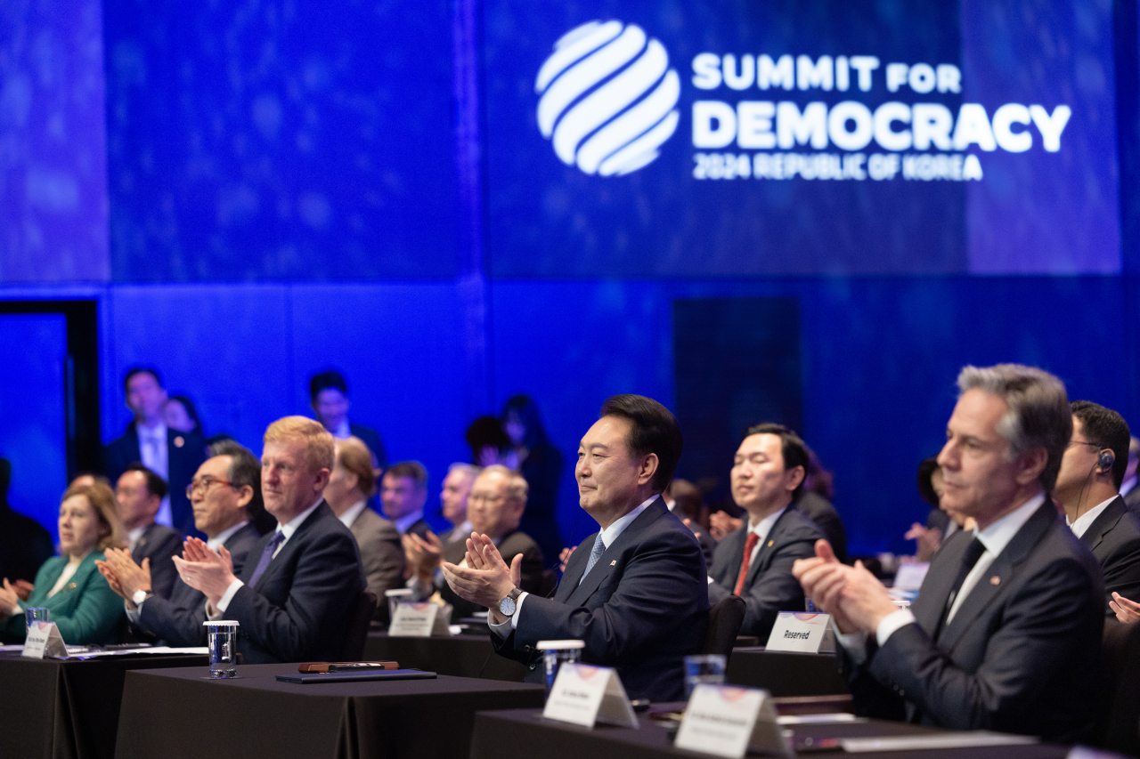 South Korean President Yoon Suk Yeol (second from left) claps during the 3rd Summit for Democracy at a hotel in Seoul on Monday. On Yoon's left is Britain's Deputy Prime Minister Oliver Dowden, and on Yoon's right is US Secretary of State Antony Blinken. (Presidential office via Yonhap)