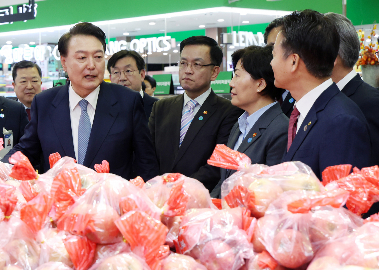 President Yoon Suk Yeol (left, front row) speaks with ministers of his administration as he visited the Nonghyup Hanaro Mart's Yangjae branch in Seocho-gu, Seoul on Monday. (Pool photo via Yonhap)