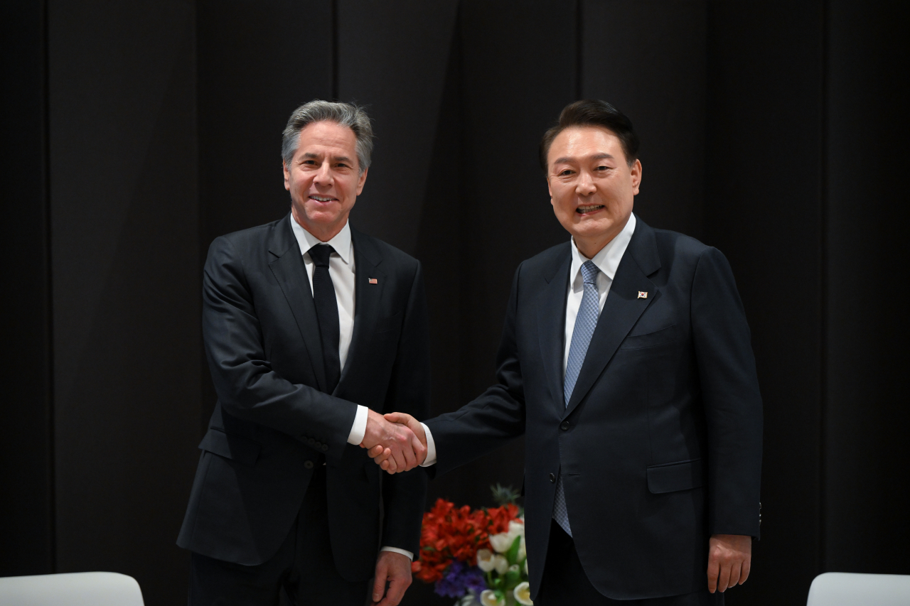 President Yoon Suk Yeol (right) and US Secretary of State Antony Blinken shake hands while meeting on the sidelines of the ministerial conference of the third Summit for Democracy at Hotel Shilla in Seoul on Monday in this photo provided by the presidential office. (Yonhap)