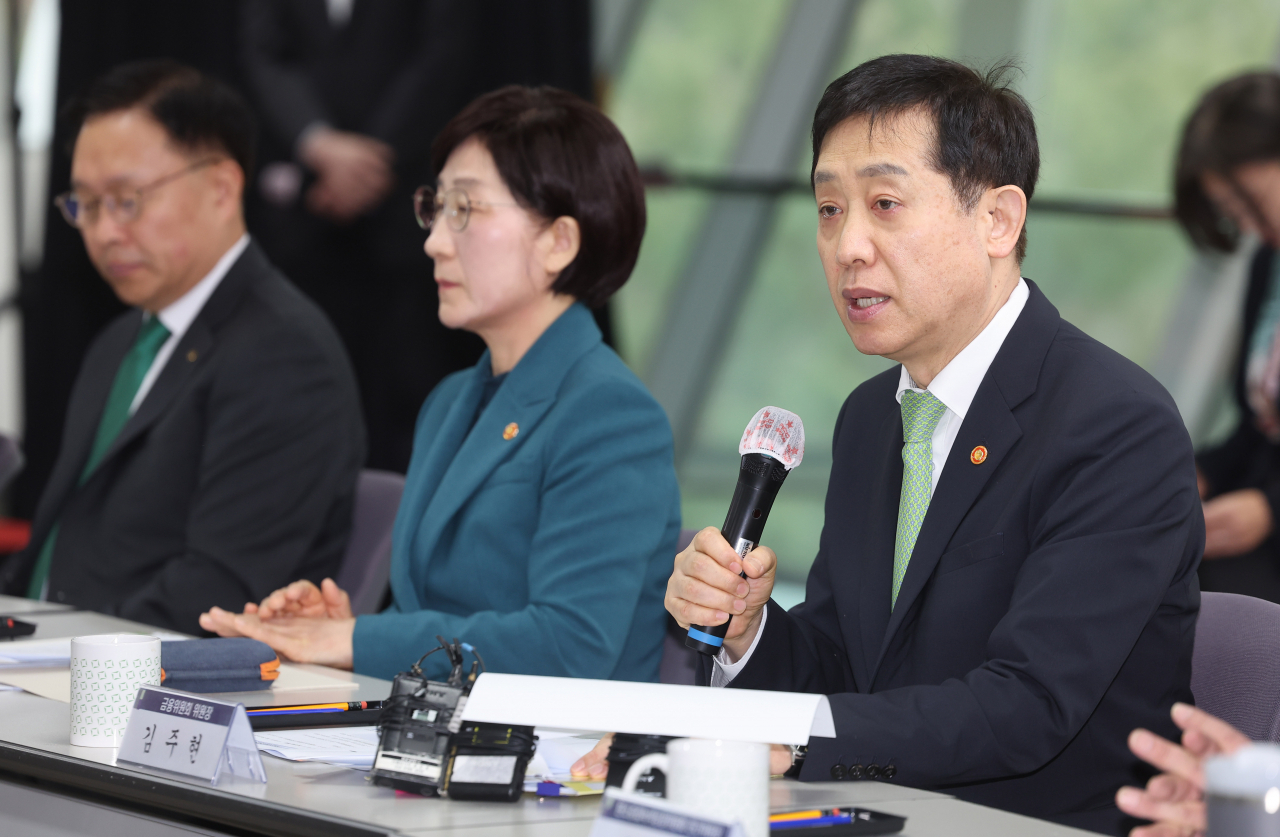 The Financial Services Commission Chairman Kim Joo-hyun (right) speaks during a meeting with government officials and the leaders of major local banks to discuss financial support to combat climate challenges held in Seoul on Tuesday. (Yonhap)