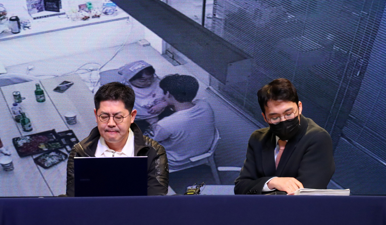 Hwang Seong-woo, CEO of Spire Entertainment (left), discloses a clip of a surveillance camera that shows Lee Hwi-chan, a member of Omega X, touching former CEO Kang Seong-hee inappropriately at a press conference in Seoul on Tuesday. (Newsis)