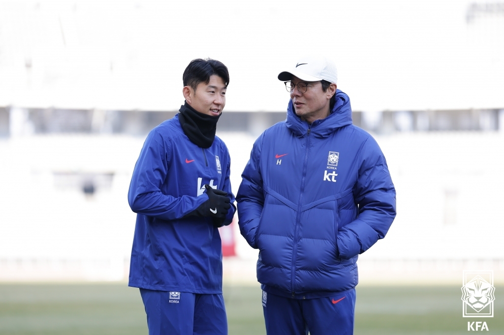 Son Heung-min, the captain of the South Korean national football team and and player for Tottenham Hotspur (left) speaks to interim head coach of Korean national football team Hwang Sun-hong at a closed workout session before the upcoming 2026 FIFA World Cup Asian second-round qualifiers against Thailand on Tuesday. (Yonhap)