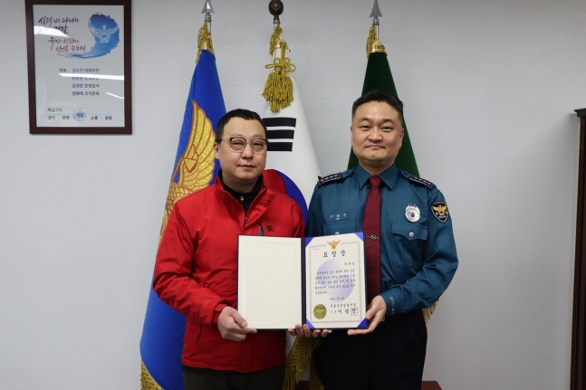 Park Gwan-yong (left) holds a certificate of commendation he received Tuesday from the Seoul Gangbuk Police Station in recognition of his contribution to the arrest of a suspected kidnapper. (Gangbuk Police Station)