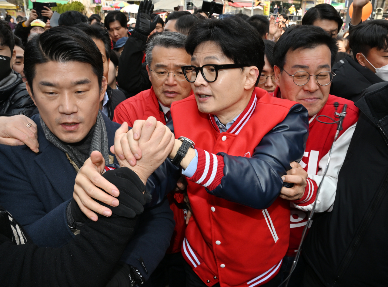 People Power Party interim leader Han Dong-hoon (third from left) greets his supporters during his visit to Anyang, Gyeonggi Province, on Wednesday. (Pool photo via Yonhap)