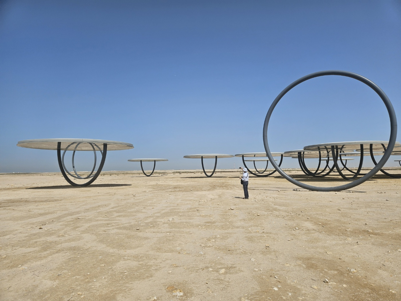 A visitor takes photos of Olafur Eliasson's “Shadows Traveling on the Sea of the Day” in the Qatari desert, Feb. 24. (Park Yuna/The Korea Herald)