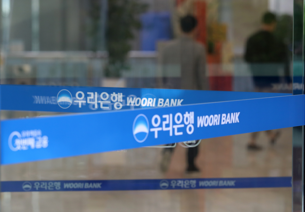 Woori Bank logo shows on the glass wall of the bank's headquarters in central Seoul. (Herald DB)