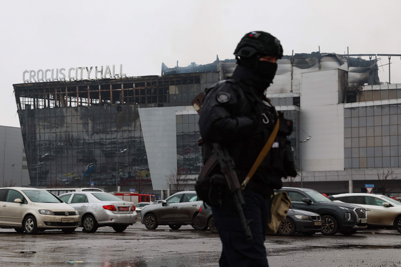 A law enforcement officer patrols the scene of the gun attack at the Crocus City Hall concert hall in Krasnogorsk, outside Moscow, on Saturday. (AFP-Yonhap)