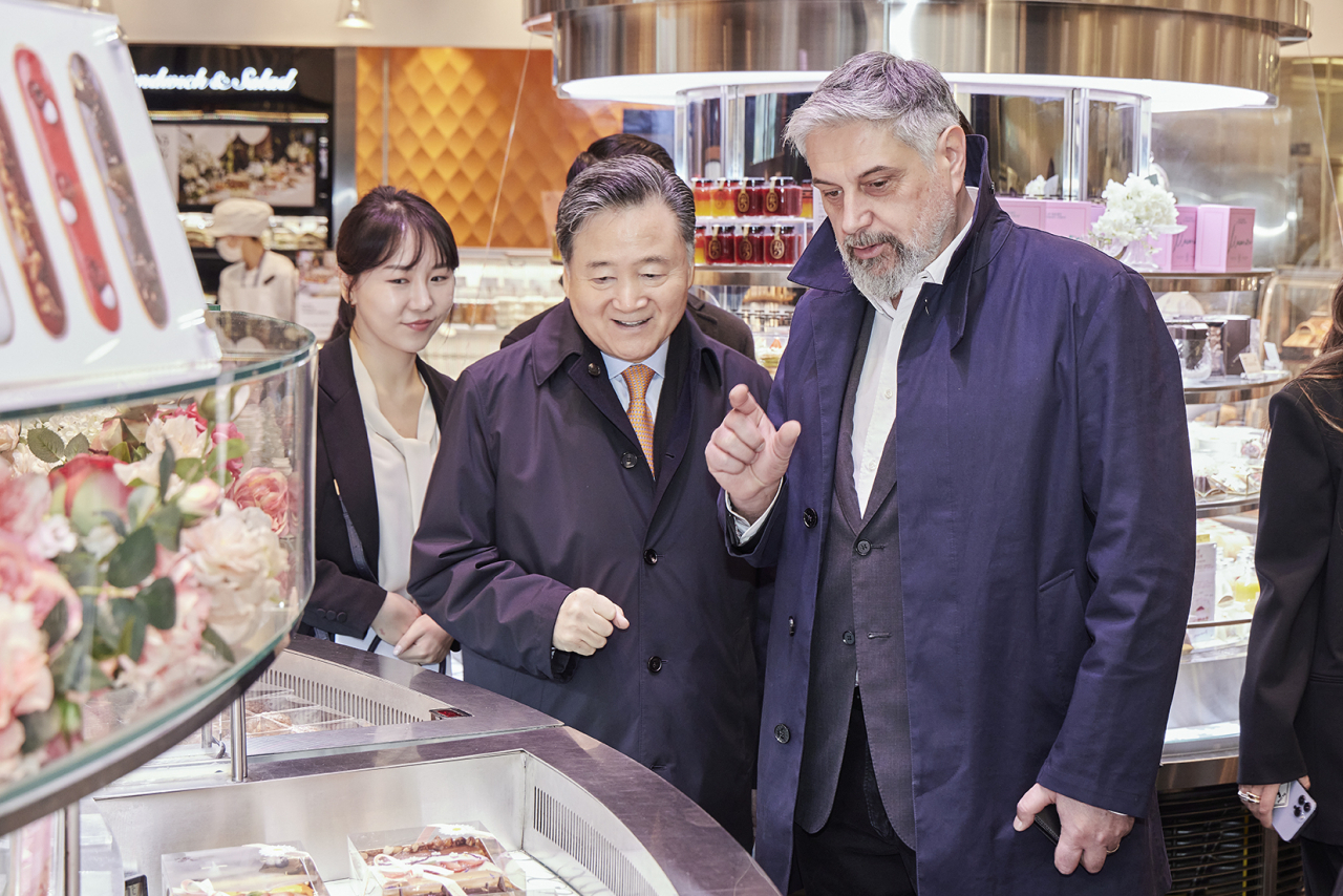SPC Group Chair Hur Young-in (left) and Caffe Pascucci CEO Mario Pascucci tour around Passion5, SPC Group's flagship bakery and dessert store in central Seoul, Sunday. (SPC Group)