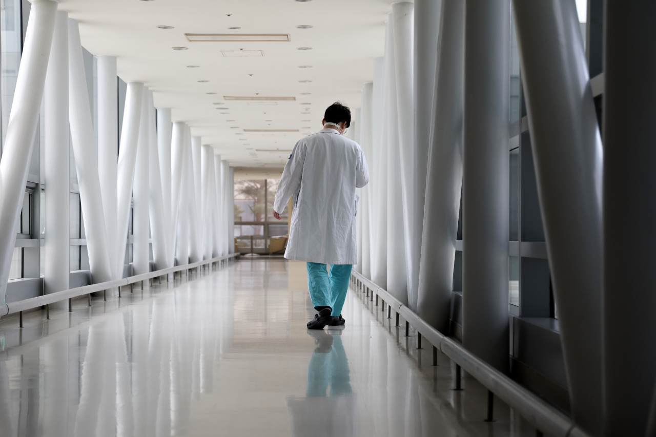A day before medical school professors pledged to hand in resignations en masse in protest against the government's plan to increase the medical school enrollment quota, a hospital worker is seen walking at a hospital in Seoul, Sunday. (Yonhap)