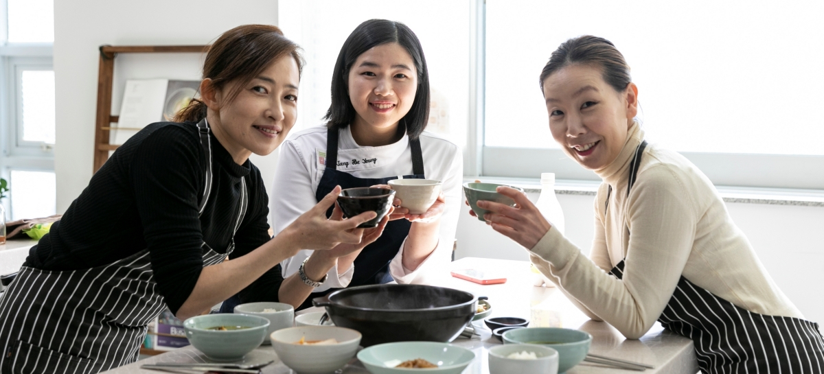 Overseas tourists and a local chef pose for photos during a cooking class in Busan. (Busan Tourism Organization)