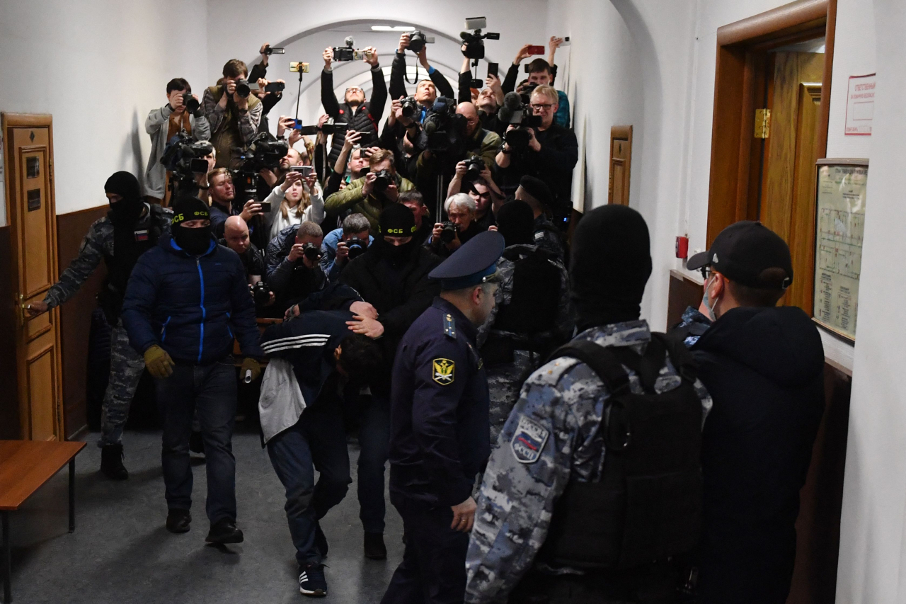 A man suspected of taking part in the attack of a concert hall that killed 137 people, the deadliest attack in Europe to have been claimed by the Islamic State jihadist group, is escorted by Russian law enforcement officers prior to his pre-trial detention hearing at the Basmanny District Court in Moscow on Monday. (AFP-Yonhap)