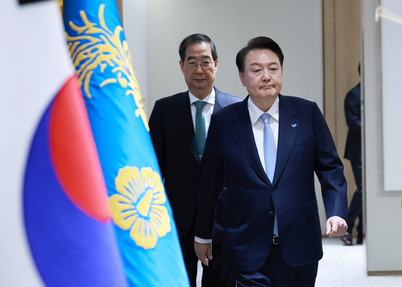 President Yoon Suk Yeol (right) enters the meeting room to preside over a Cabinet meeting held in his office on Tuesday. (Yonhap)