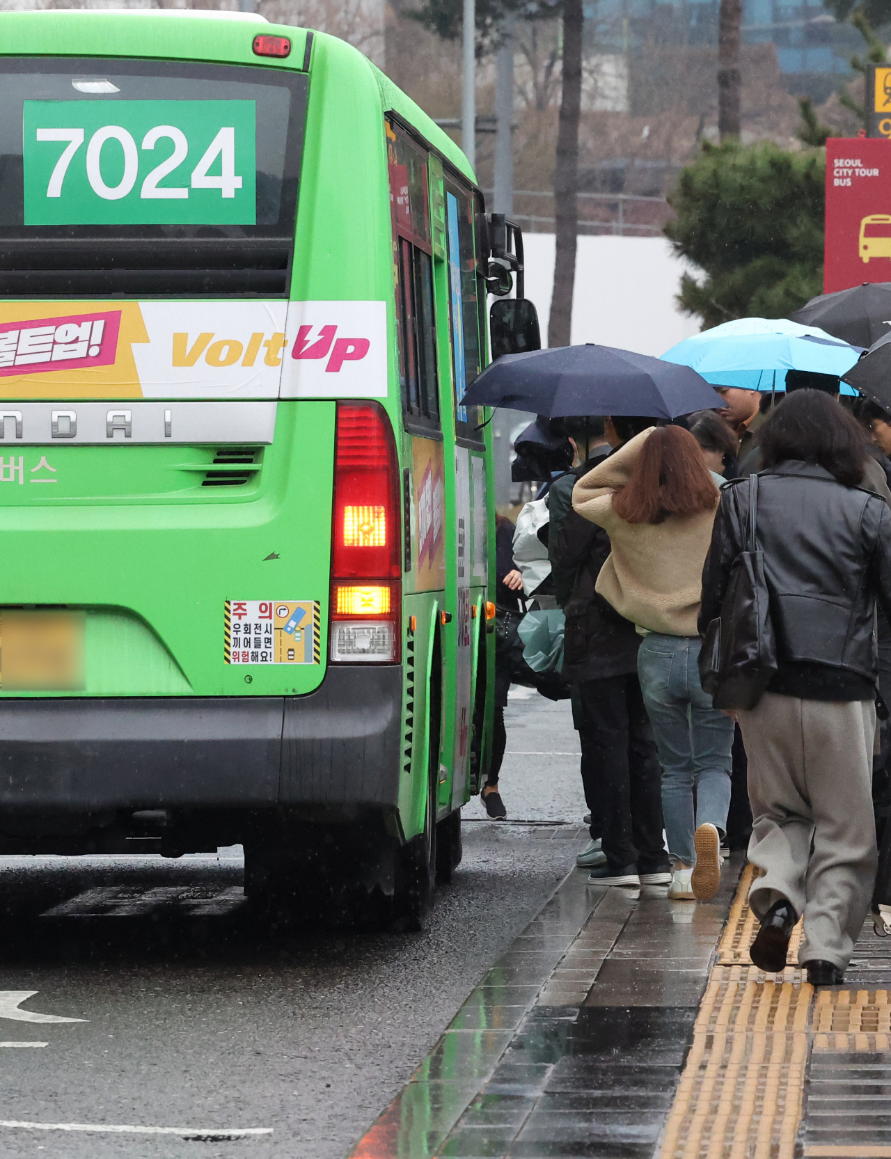 People board a No. 7024 bus at a stop near Seoul Station on Thursday. No. 7024 is one of the few operational buses amid the citywide strike of unionized bus drivers. (Yonhap)