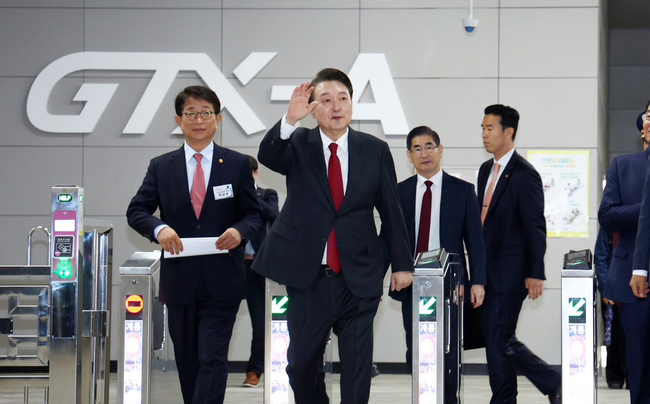 President Yoon Suk Yeol (second from left) waves hands as he arrived at Dongtan Station in Hwaseong, Gyeonggi Province, after a 20-minute test run of GTX-A train from Suseo Station of Seoul on Friday. (Pool photo via Yonhap)
