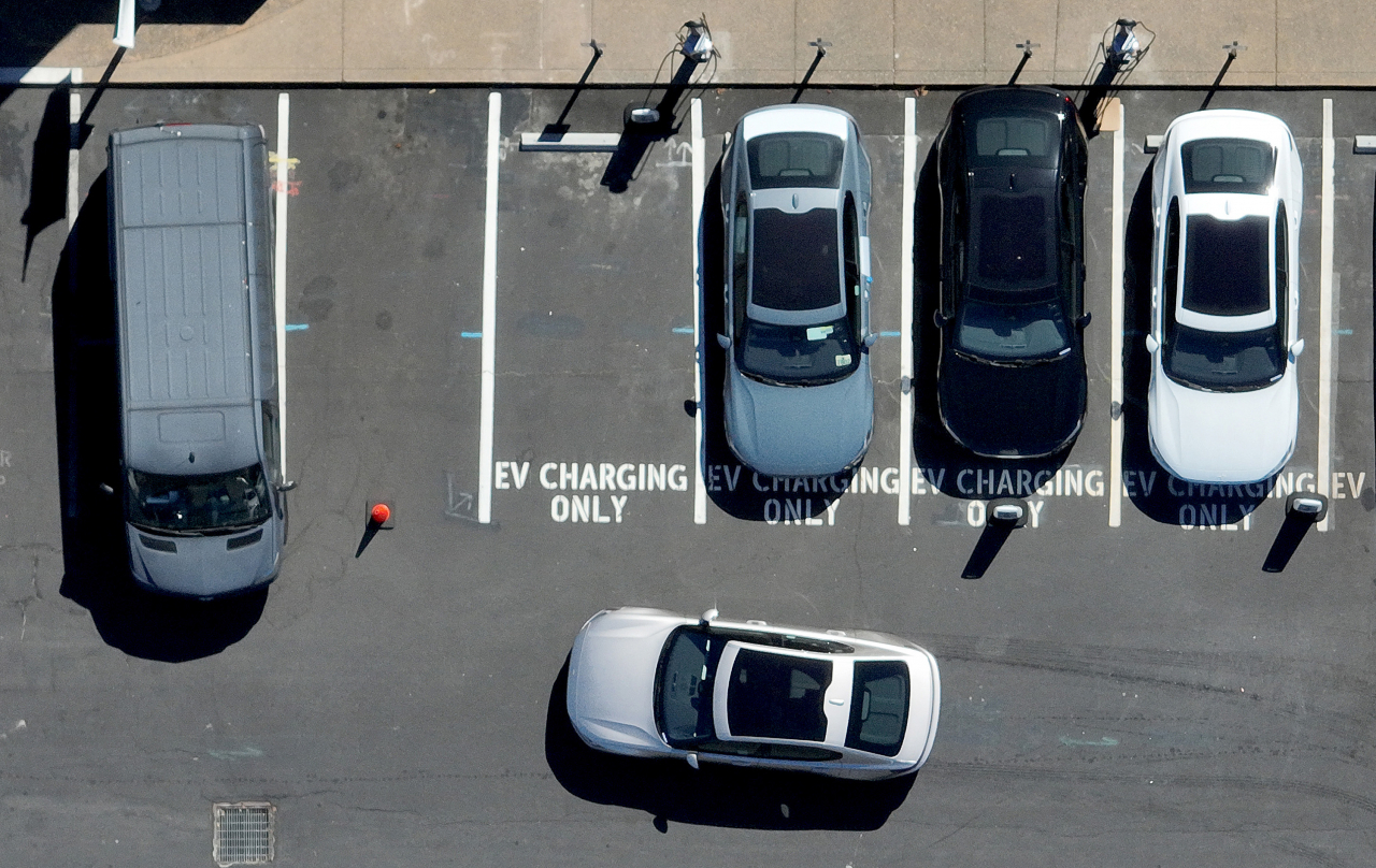 EVs parked at charging stations at a parking lot (Getty Images)
