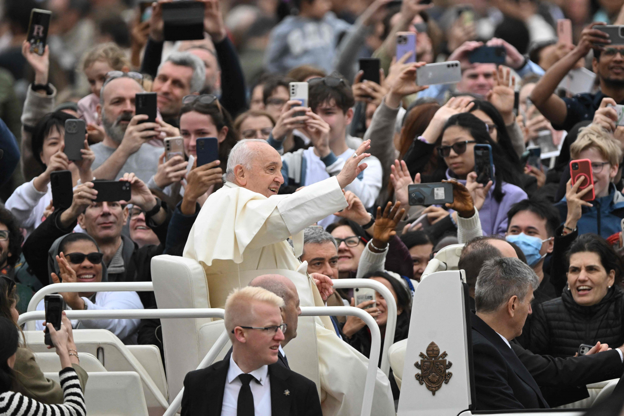 Pope Francis waves to the crowd from the popemobile after the Easter Mass as part of the Holy Week celebrations, at St Peter's square in the Vatican on March 31, 2024. (AFP-Yonhap)