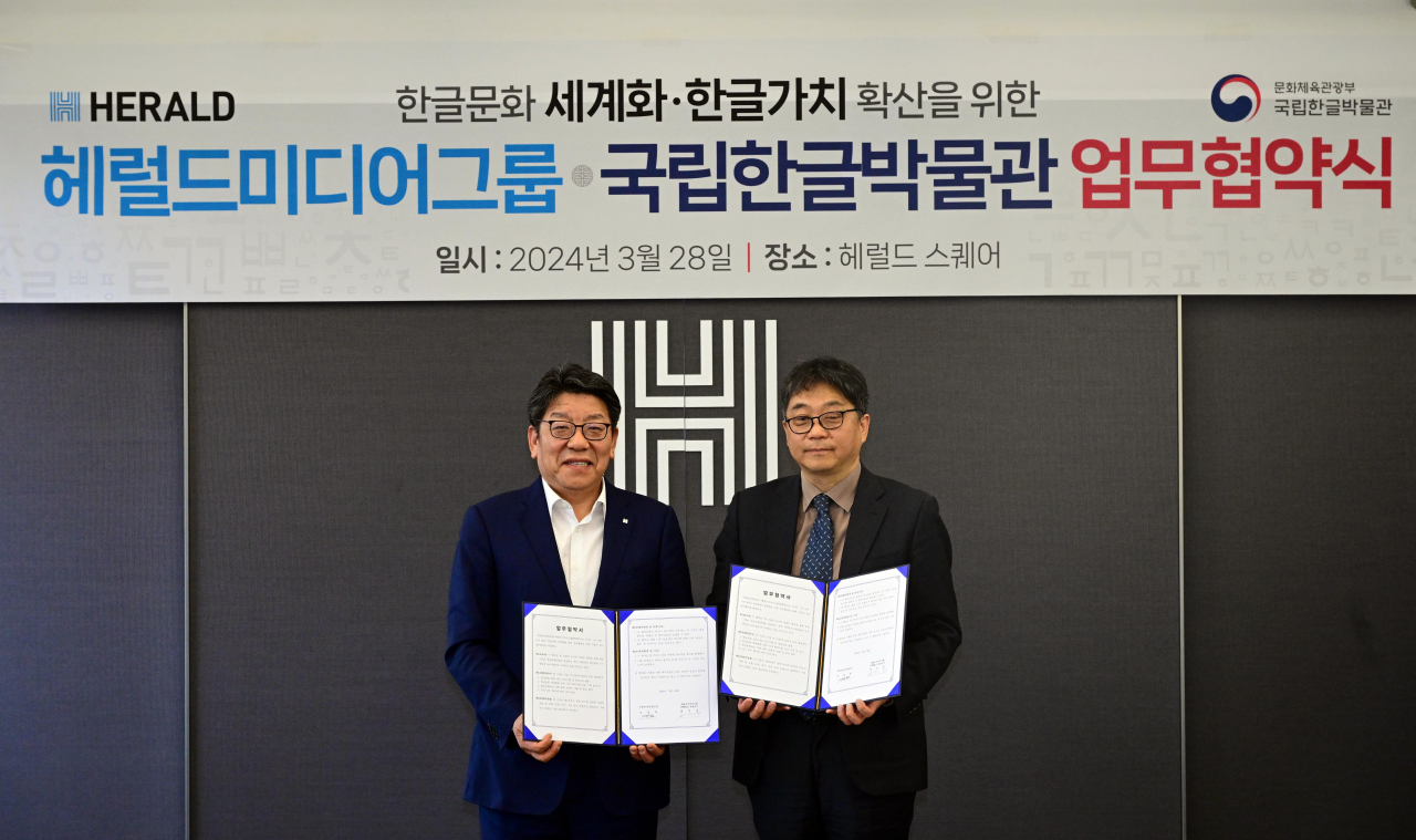 Herald Corp. CEO Choi Jin-young and National Hangeul Museum director Kim Il-hwan pose for a photograph after signing a memorandum of understanding at the Herald Corp.'s headquarters on March 28. (Herald Corp.)