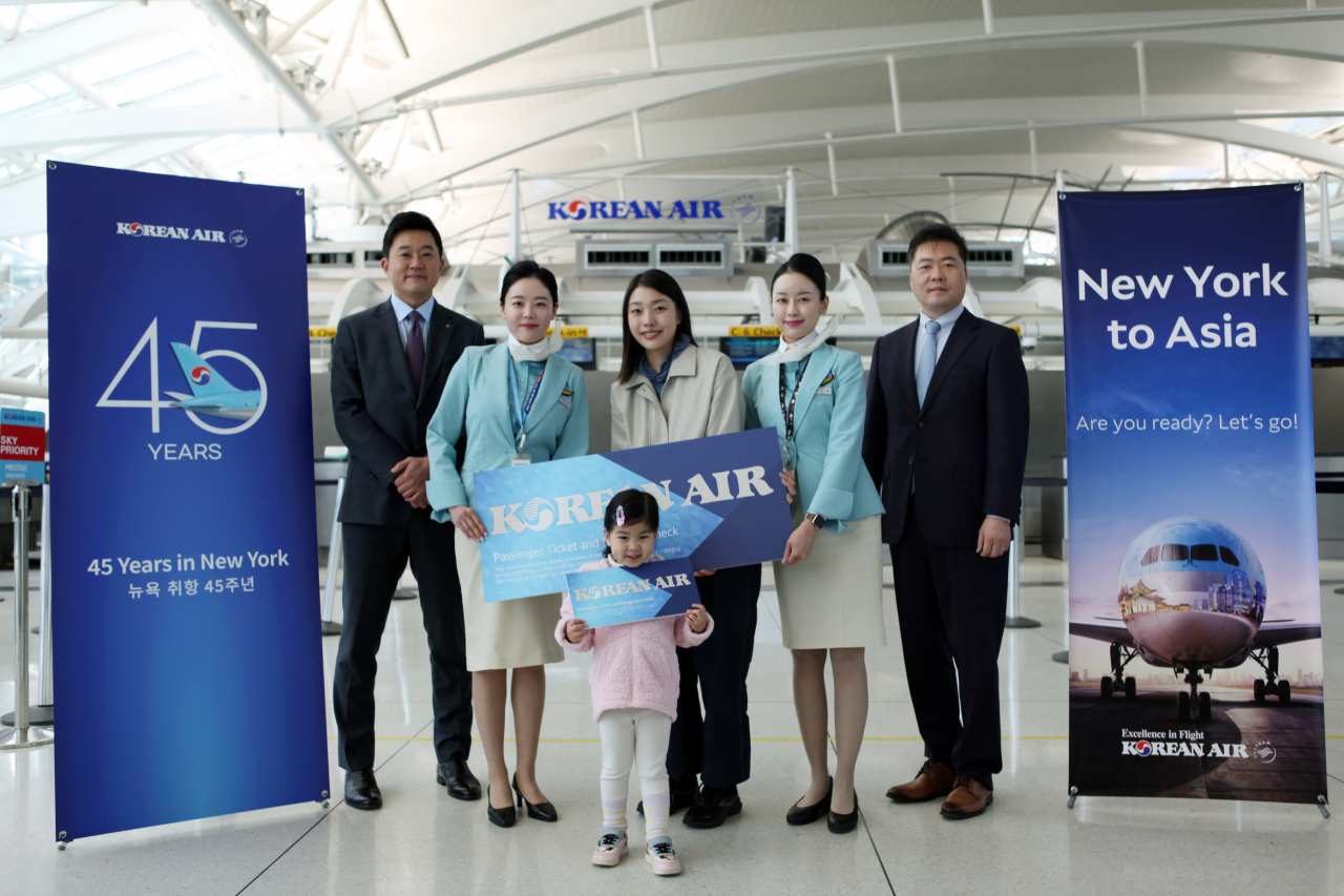The winner of the complimentary round-trip flight ticket to New York poses for a photo with Korean Air officials at the JFK Airport on Friday. (Korean Air)