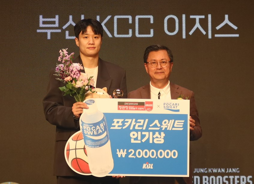 Busan KCC’s Heo Ung (left) is awarded the Pocari Sweat Popularity Award during the 2023-2024 JungKwanJang KBL Awards at a hotel in Seoul on Monday. (Dong-A Otsuka)