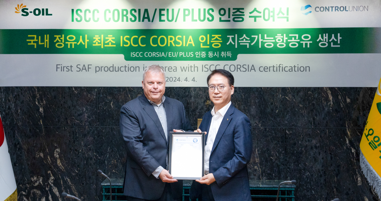Ryu Yul (right), president for corporate strategy and services at S-Oil, and Dirk Teichert, Control Union's regional manager for Asia, pose for a photo during an awarding ceremony held at the refiner's Seoul headquarters on Thursday. (S-Oil)