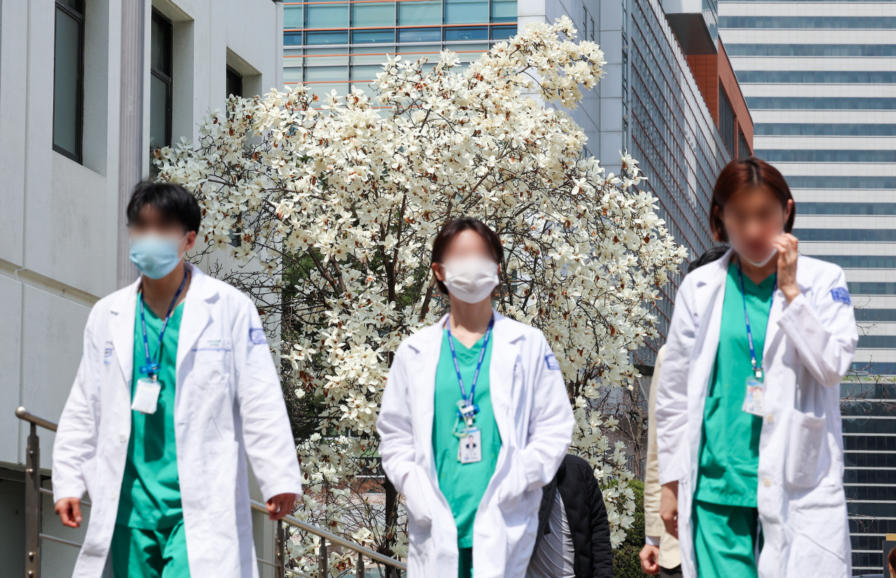 Doctors walk outside a university hospital in Seoul on Thursday (Yonhap)