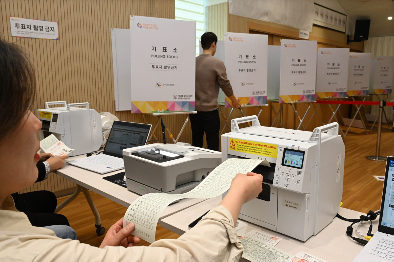Workers inspect a polling station at an early voting center in Jongno-gu, central Seoul on Thursday, the day before the early voting period for the 22nd general election takes place. (Joint Press Corps)