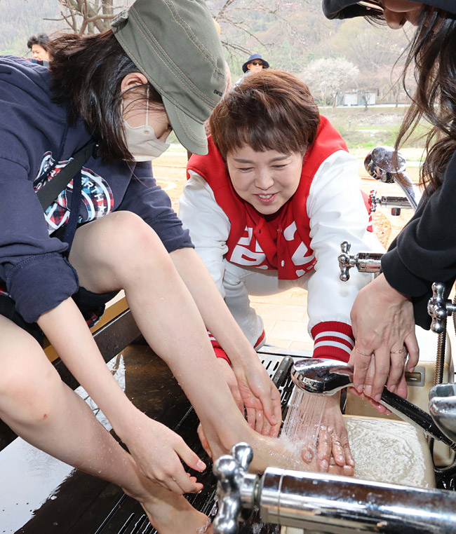 Kim Eun-hye, a candidate for the People's Power Party in Seongnam, Gyeonggi Province, washes the feet of public members at a red clay road. (Kim Eun-hye campaign)