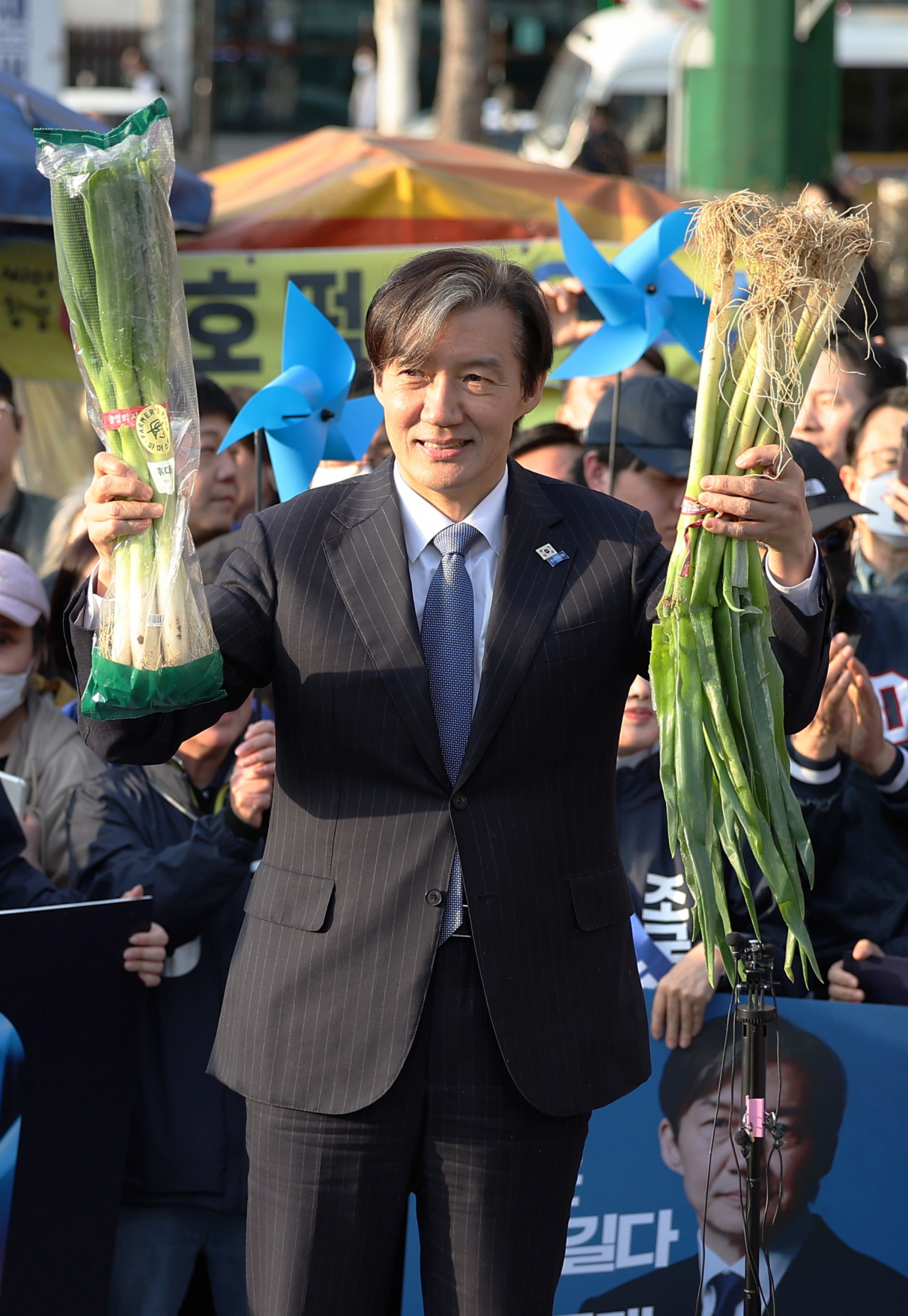 Cho Kuk, who leads the Rebuilding Korea Party, holds bundles of scallions during his visit to Seongnam, Gyeonggi Province, on April 1. (Yonhap)