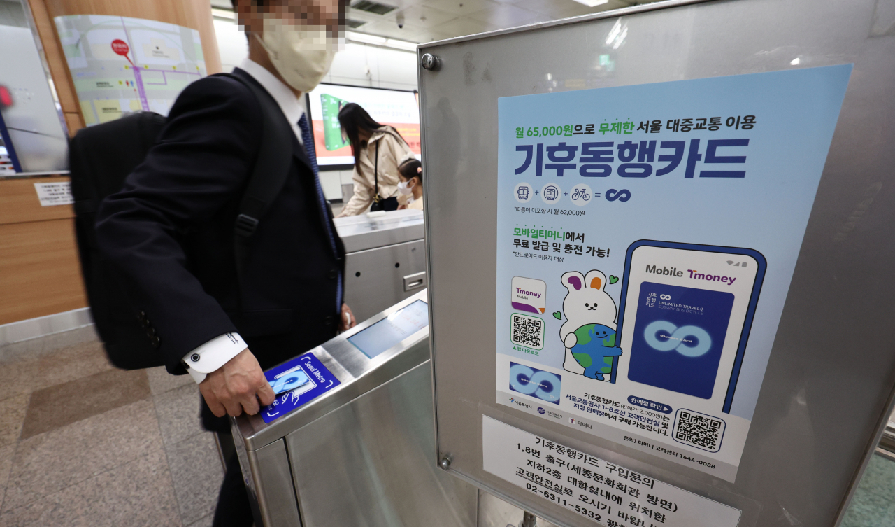 Commuters pass through the turnstiles in a subway station in Seoul on Sunday. (Yonhap)