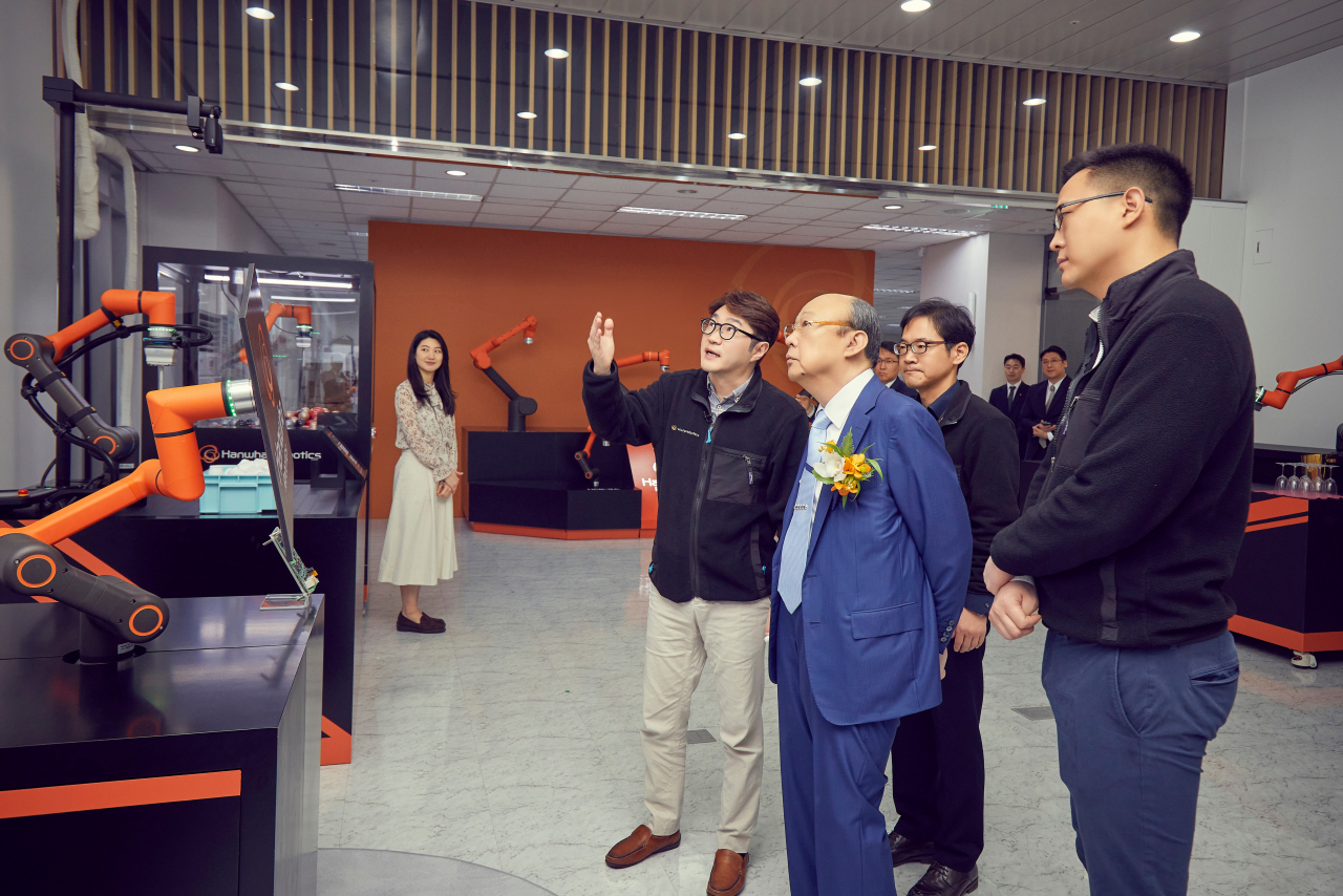Hanwha Group Chairman Kim Seung-youn (third from right) looks around Hanwha Robotics headquarters with Kim Dong-seon (right), his third and youngest son and the vice president of Hanwha Hotel & Resorts, on Friday. (Hanwha Group)