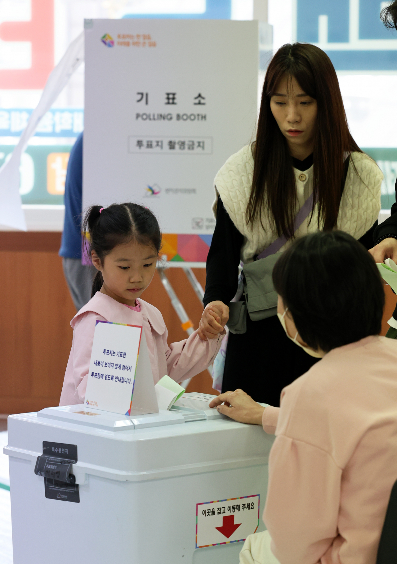 A voter casts her ballot with her child at a polling station in Gwangju, Wednesday. (Yonhap)