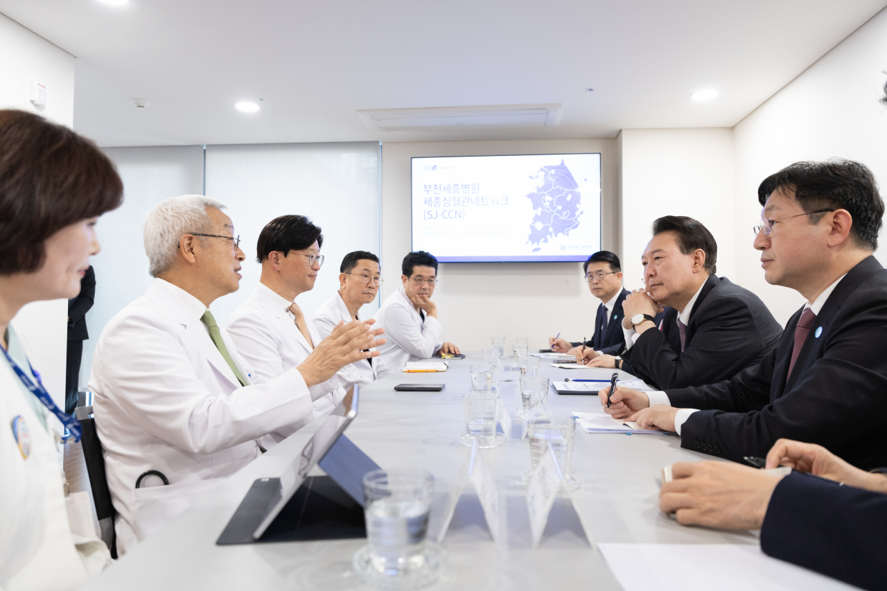 President Yoon Suk Yeol (second from right) speaks to senior doctors at Bucheon Sejong Hospital in Bucheon, Gyeonggi Province, just southwest of Seoul, on Tuesday. (Yonhap)