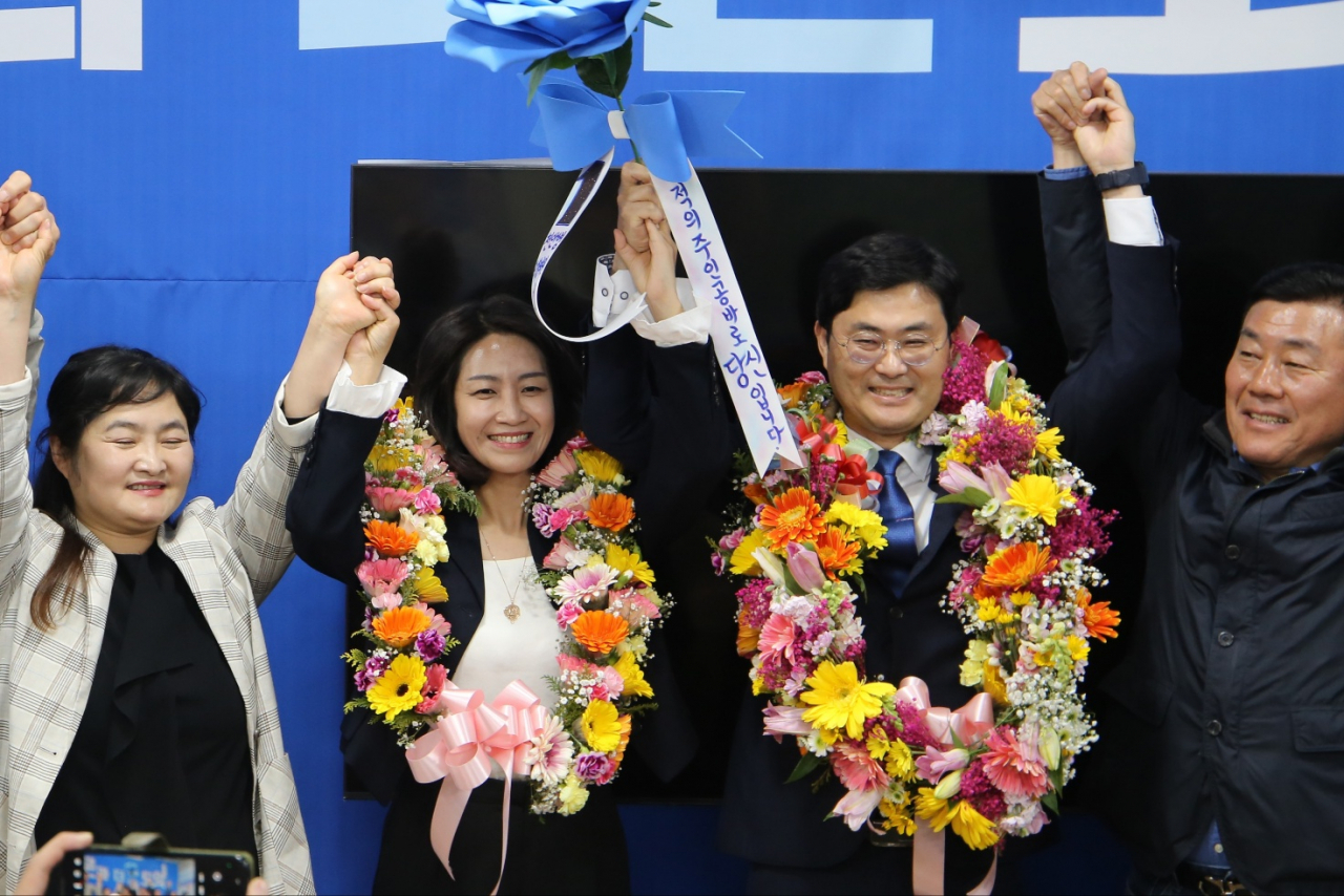Democratic Party of Korea candidate Kim Dong-ah, center right, celebrates his victory at Seodaemun-A constituency in Seoul on late Wednesday. (Yonhap)