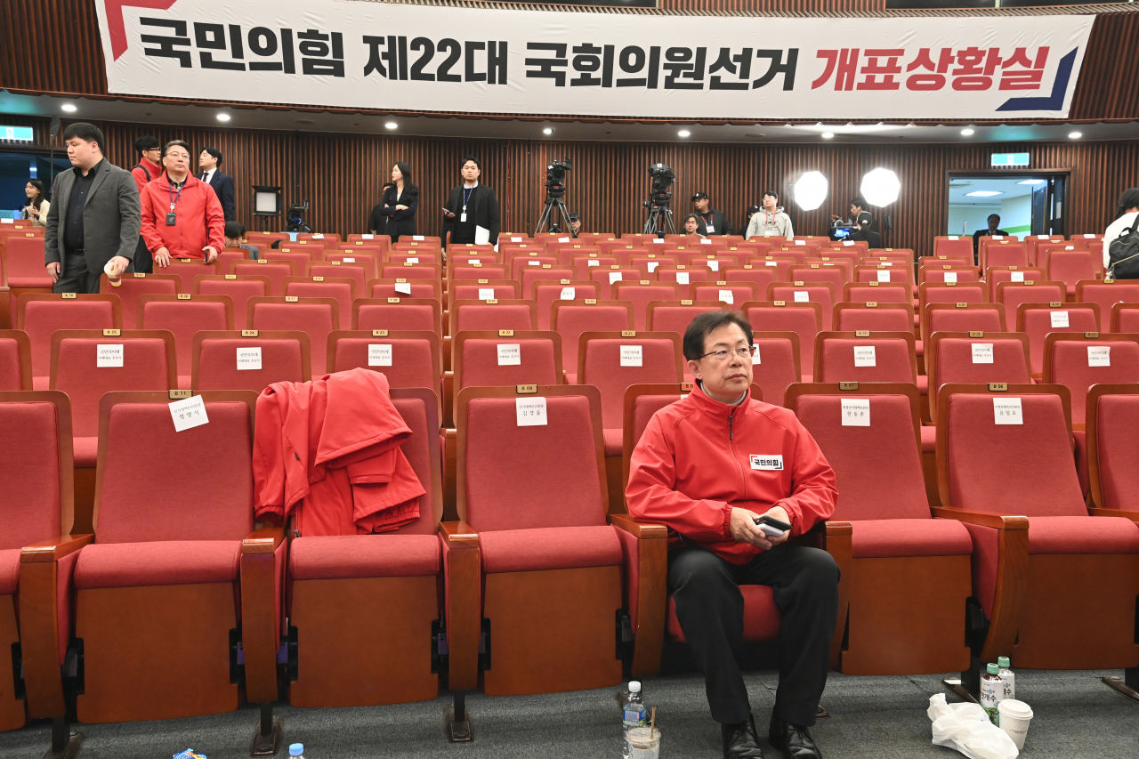 Lee Man-hee, head of the People Power Party's vote counting office, sits in an empty National Assembly hall after party members left in disappointment over the party's overwhelming defeat, Wednesday evening. (Yonhap)