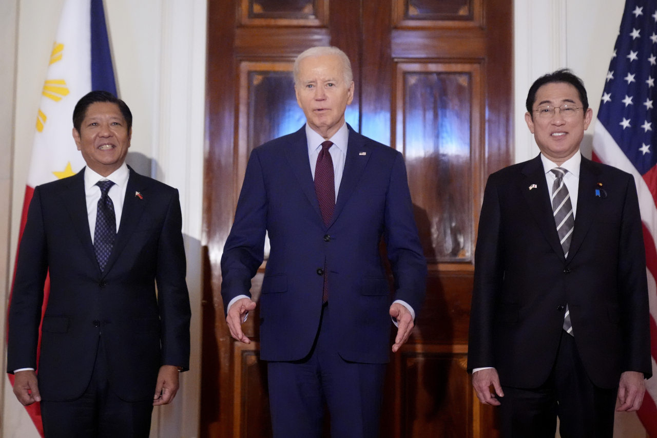U.S. President Joe Biden (center) stands alongside Philippine President Ferdinand Marcos Jr. (left) and Japanese Prime Minister Fumio Kishida before a trilateral meeting at the White House in Washington on Thursday. (AP-Yonhap)
