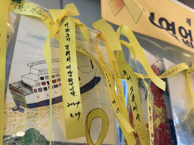 Yellow ribbons, used commonly to express sympathy and condolences for the victims of the Sewol ferry disaster, are tied to a rope at the Sewol ferry memorial space at Jindo Port in Jindo, South Jeolla Province. One ribbon in the photo reads: 