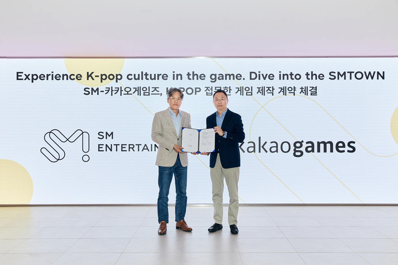 Co-CEO of SM Entertainment Jang Cheol-hyuk (left) and CEO of Kakao Games Corp. Hang Sang-woo signed a partnership Monday to launch a mobile game in the second half of this year. (SM Entertainment)