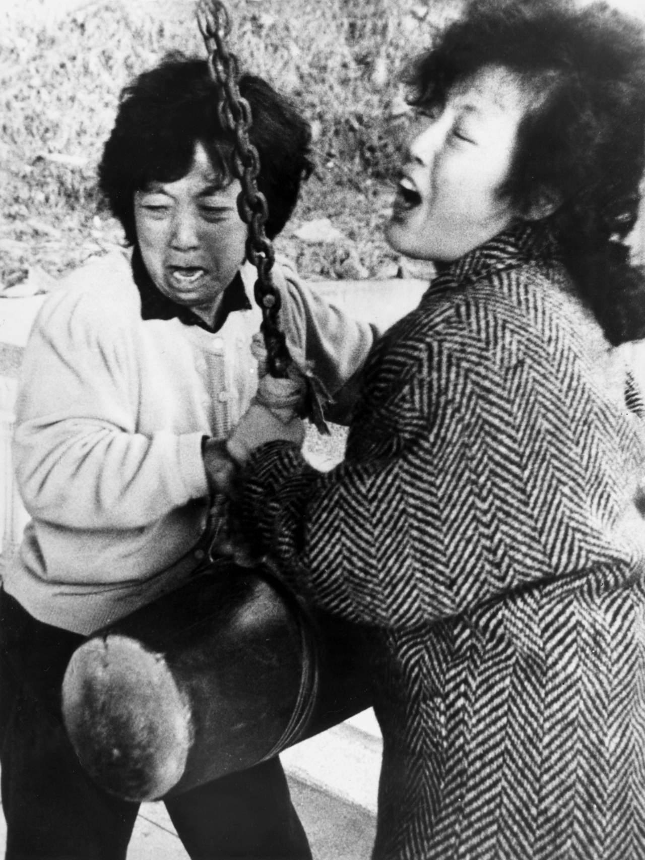 This photo from Feb. 7, 1987, shows Jeong Cha-sun (right), as she rings a bell and cries over the death of her youngest son Park Jong-chul, at a Buddhist event in Busan, along with her daughter Eun-suk. (Yonhap)
