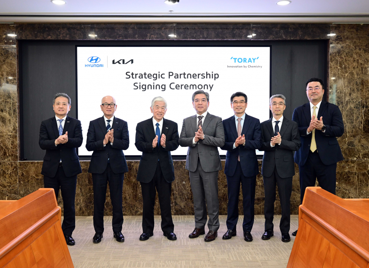 Officials from Hyundai Motor Group and Toray Industries, including Akihiro Nikkaku (third from left), chairman of Toray Industries; Mitsuo Ohya (second from left), president at Toray Industries; Chang Jae-hoon (center), CEO of Hyundai Motor Company; and Song Ho-sung (third from right), CEO of Kia, pose for a photo after signing a partnership agreement at Hyundai Motor’s headquarters in Seoul on Thursday. (Hyundai Motor Group)