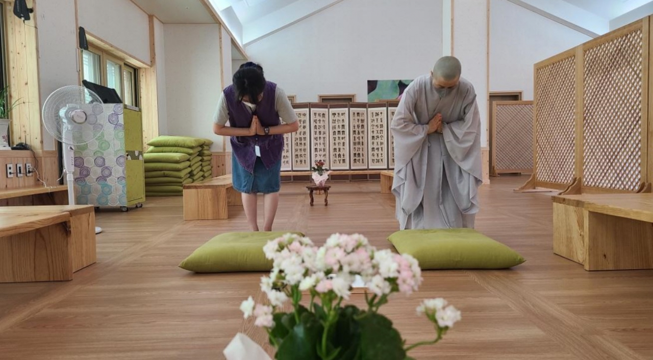 A Templestay program participant bows with a Buddhist monk at Yonghwasa in Cheongju. (Yonghwasa)