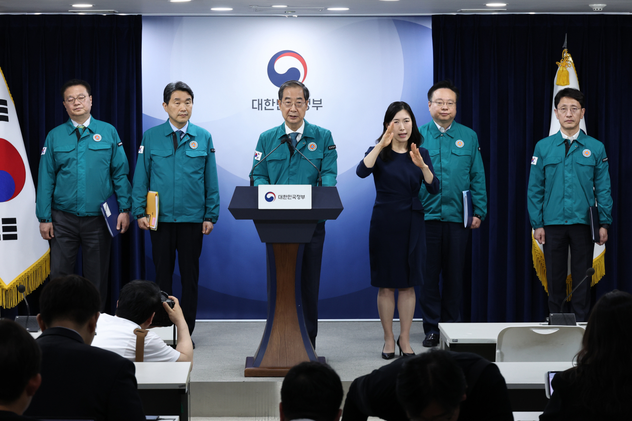Prime Minister Han Duck-soo (center) gives a special briefing at the government complex in Seoul on Friday, announcing the government's decision to accept a suggestion from the heads of six national universities to scale back the expansion of medical student enrollment. (Yonhap)
