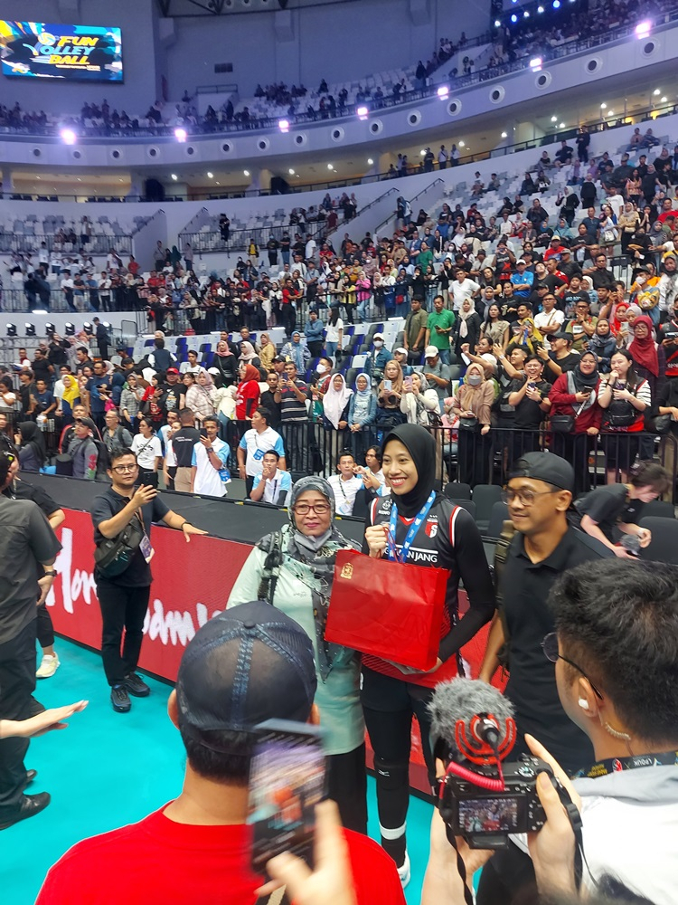 Indonesian volleyball star Megawati Pertiwi (center), alongside her mother and older brother, poses for a photo after a volleyball game held in Jakarta, Indonesia, Saturday. (Korea Ginseng Corp.)
