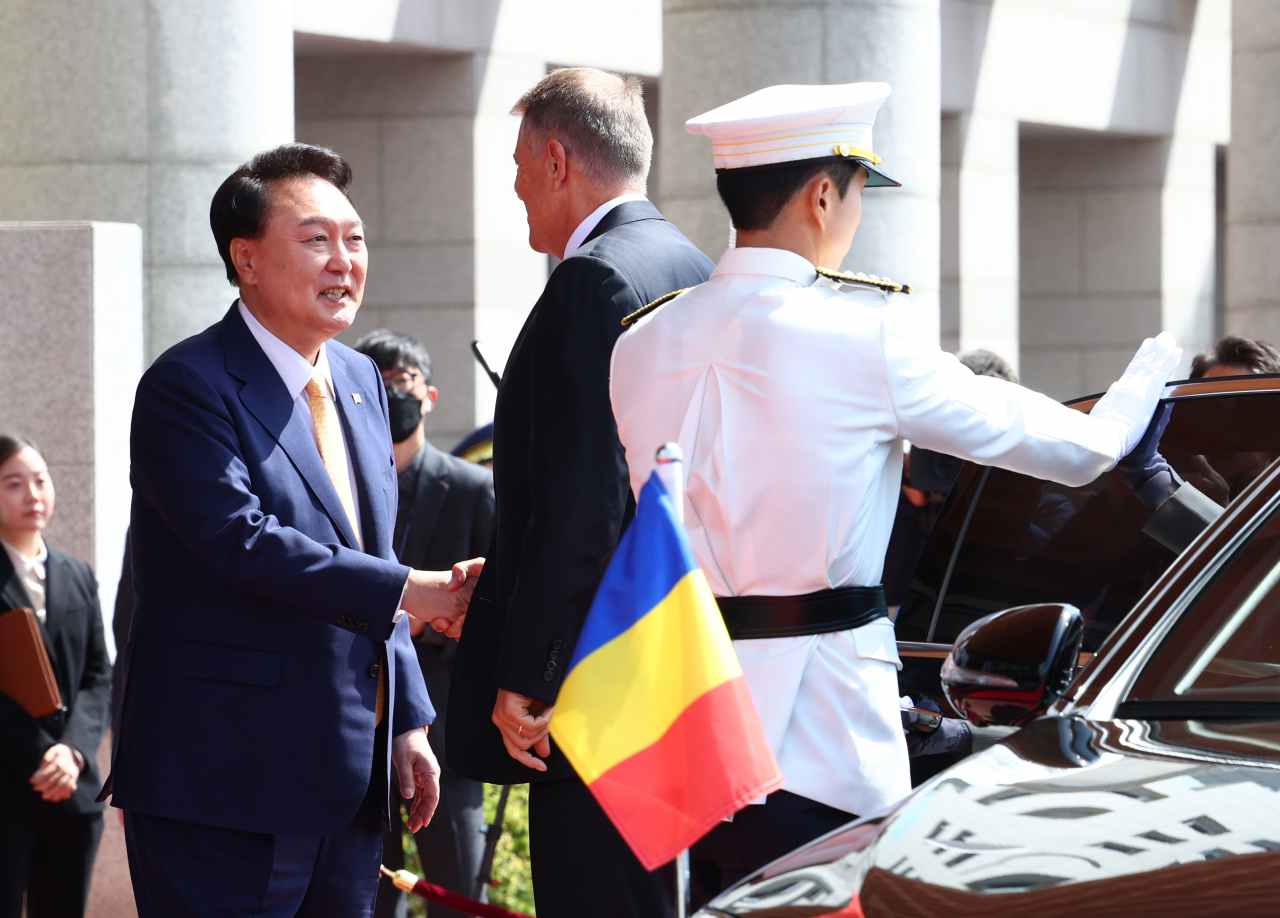 South Korean President Yoon Suk Yeol (left) receives his Romanian counterpart, Klaus Iohannis (second from left), during a welcoming ceremony at the presidential office in Seoul on Tuesday. (Pool photo via Yonhap)