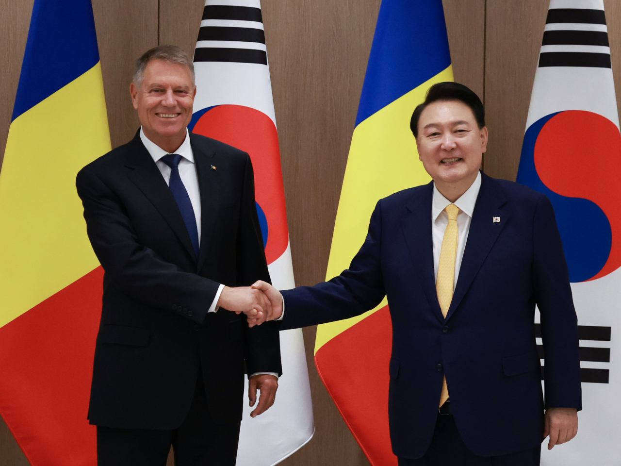 President Yoon Suk Yeol (right) shakes hands with Romanian President Klaus Iohannis during Iohannis's official visit to South Korea at Yoon's office on Tuesday. (Yonhap)