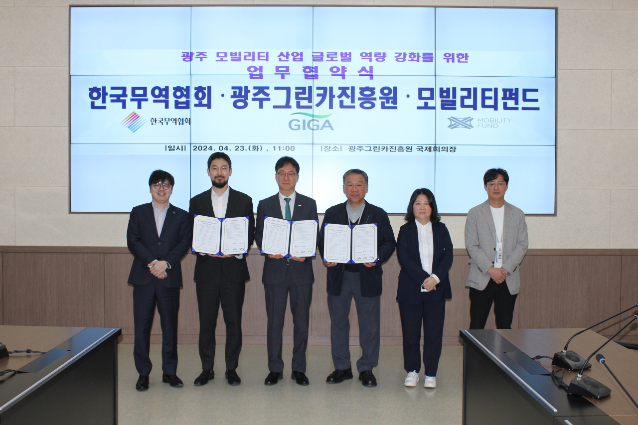 Lee Dong-won (third from left), director of Korea International Trade Association's Gwangju and South Jeolla Province regional headquarters, poses for picture during a signing ceremony for a memorandum of understanding with the Gwangju Green Car Promotion Agency and MobiltiyFund in this picture provided by KITA on Tuesday. (Korea International Trade Association)