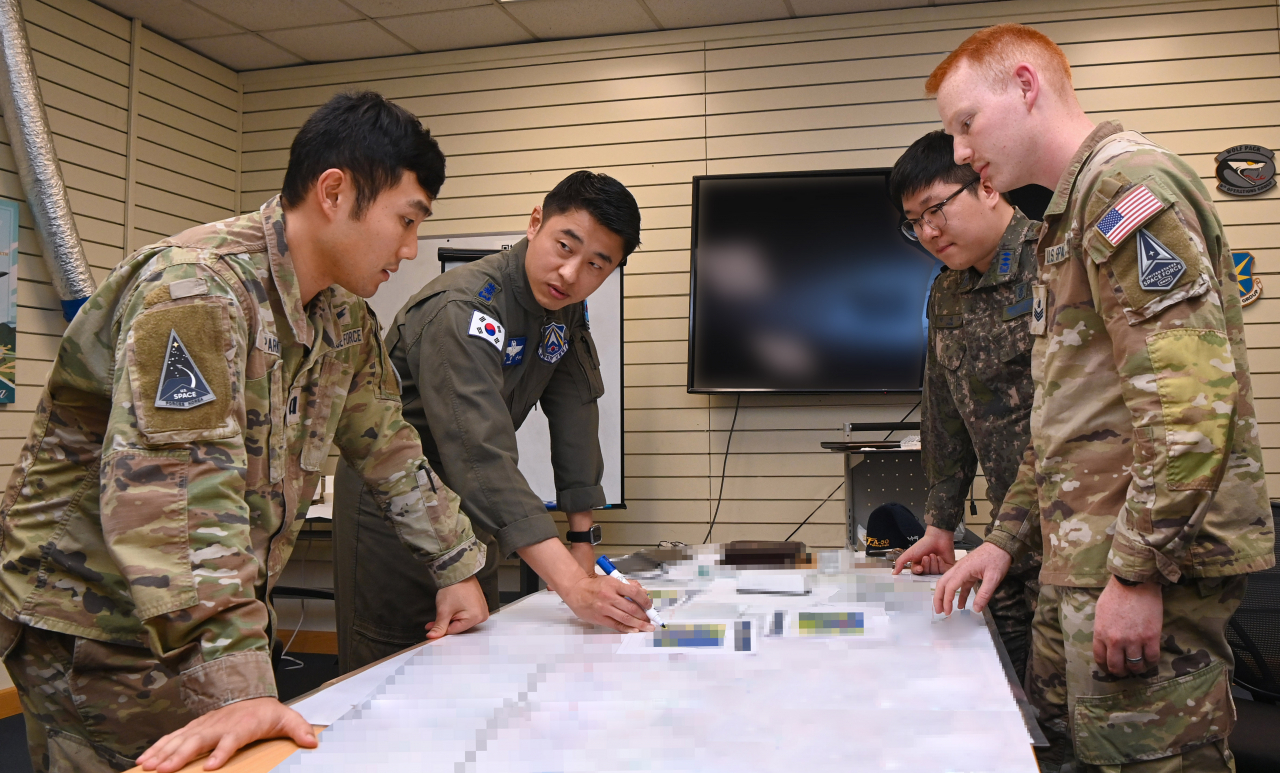 Military personnel of the South Korean Air Force's Space Operation Squadron and the United States Space Forces Korea analyze coordinates of jamming attacks during joint training exercises held at an air base in Gunsan, 178 kilometers south of Seoul, on Monday. (Air Force)