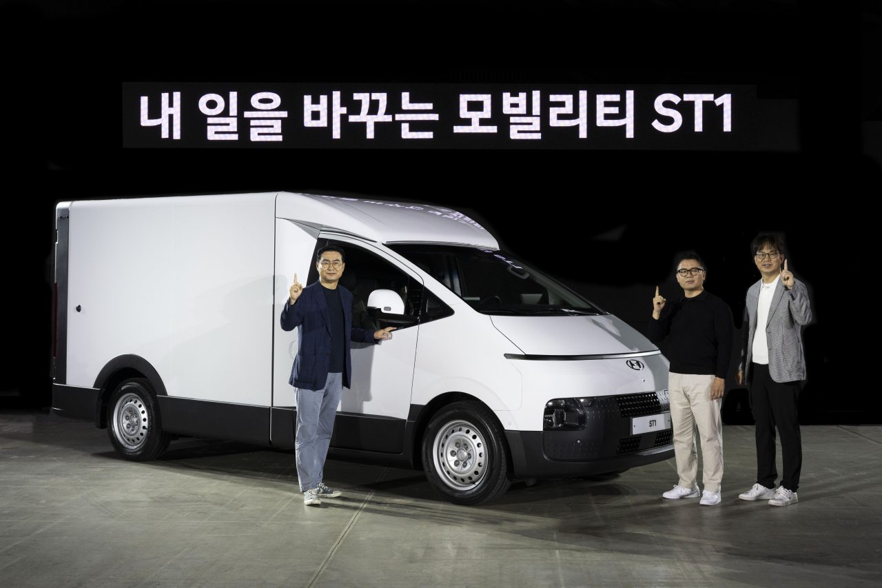 From left: Jeong Yoo-seok, vice president and head of domestic business of Hyundai Motor Company, Min Sang-ki, head of PBV (purpose-built vehicle) business, and Oh Se-hoon, director of PBV development, pose in front of the carmaker's new ST1 vehicle unveiled at the Convensia showroom in Songdo, Incheon, Tuesday. (Hyundai Motor Group)